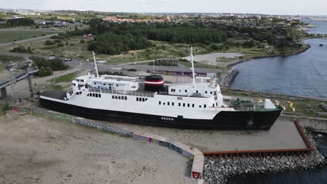 Altes-Boot-Im-Hafen-In-Der-Nähe-Einer-Großen-Brücke-über-Das-Meer