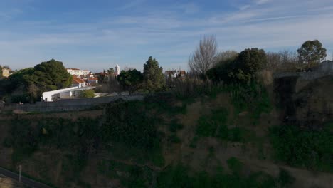 Aerial-revealing-shot-showing-historic-city-of-Almada-Town-in-Portugal-with-port-during-sunset-time