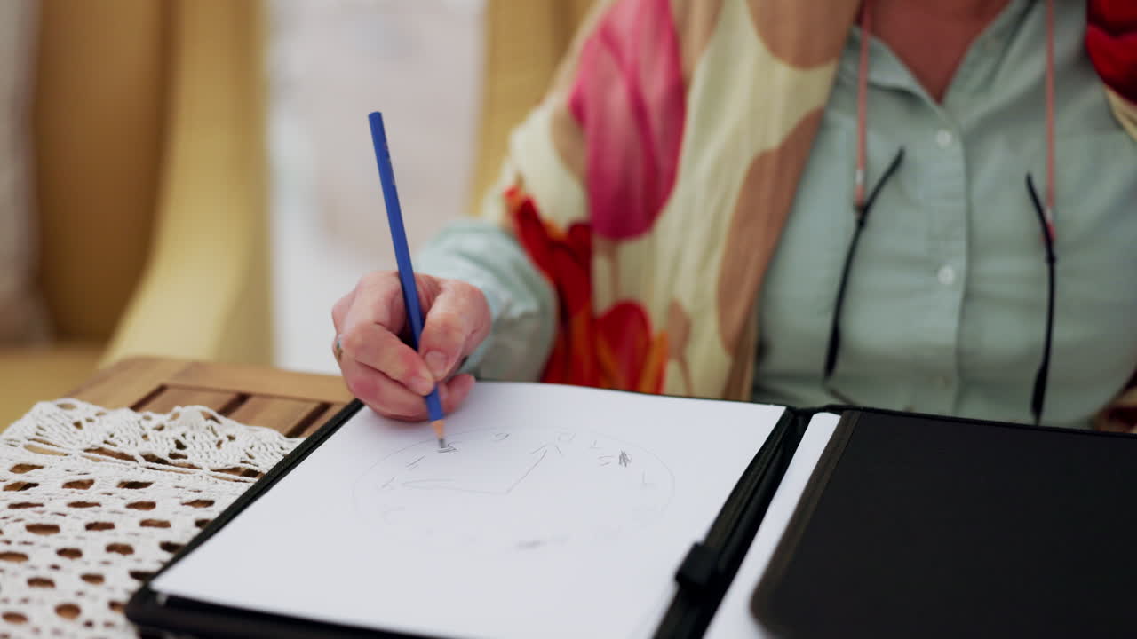 manos en primer plano, mesa y una persona dibujando en papel