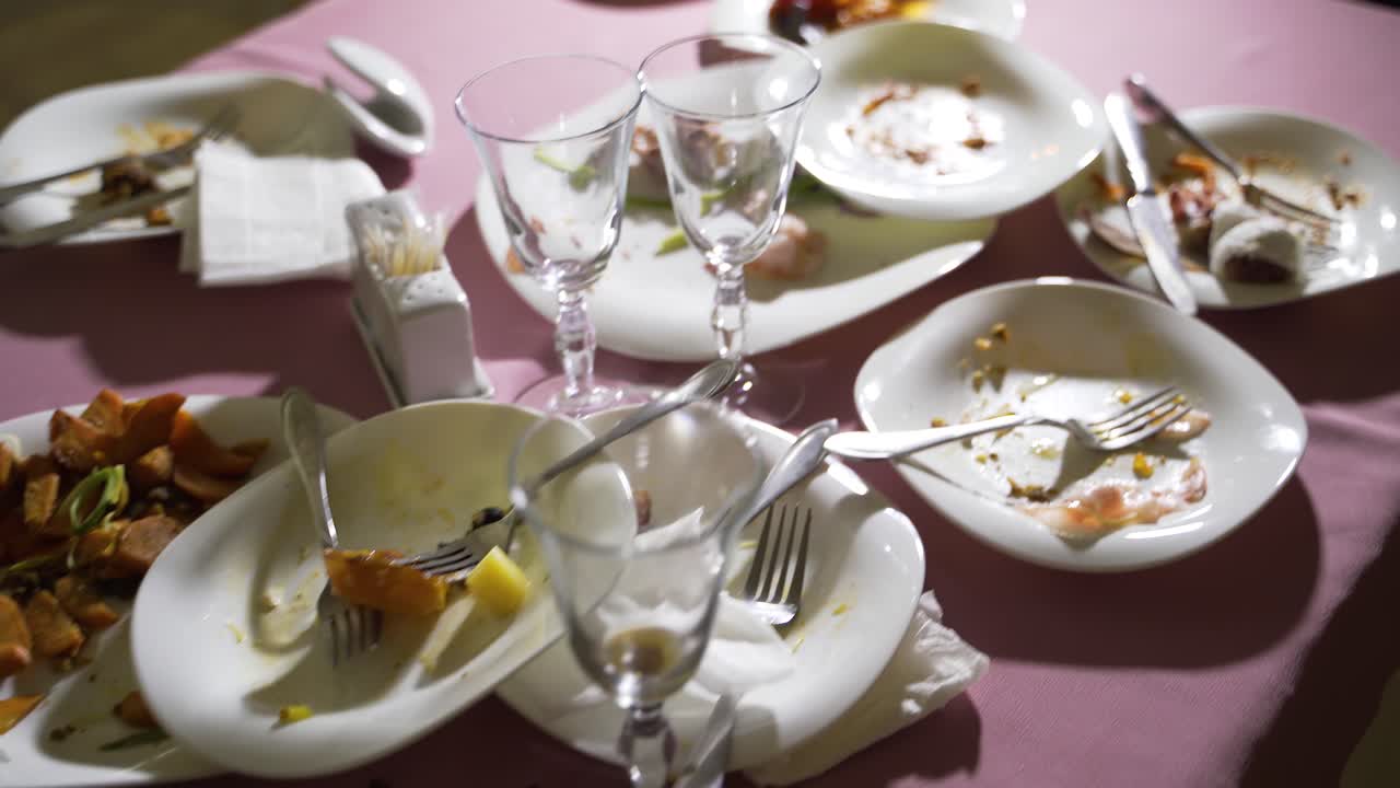 Residue of foodstuffs in the white plastic dish on wooden table. Finished with dinner