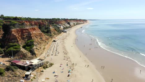 Touristen-Genießen-Sandstrand-Mit-Restaurants---Küstenklippen-Und-Meereslandschaft-Vom-Falesia-Strand-An-Der-Algarve,-Albufeira,-Portugal