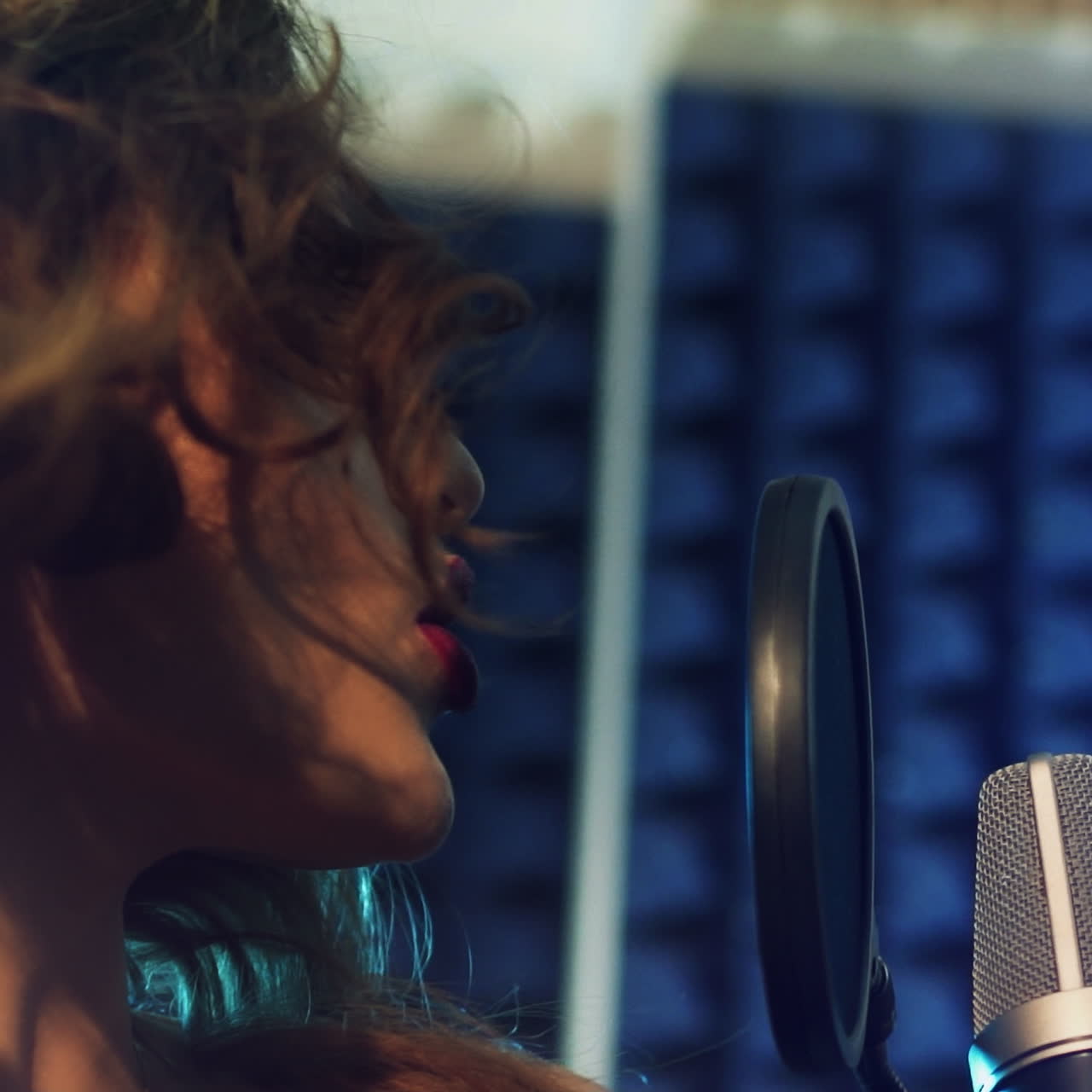 Young female singer recording album in the professional recording studio. Slow motion Square video