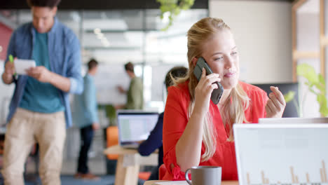 Happy-caucasian-casual-businesswoman-talking-on-smartphone-in-casual-office,-slow-motion