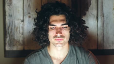 un joven muy cansado trabajando hasta tarde en casa usando su portátil