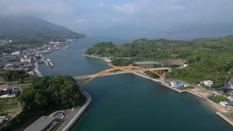 slow cinematic drone tilt up over seto inland sea with yellow bridge