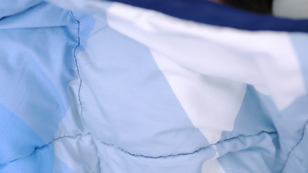 아름 다운 여성 웃 고 카메라와 담요로 덮여 침대에 사랑 스러운 거짓말을 보고