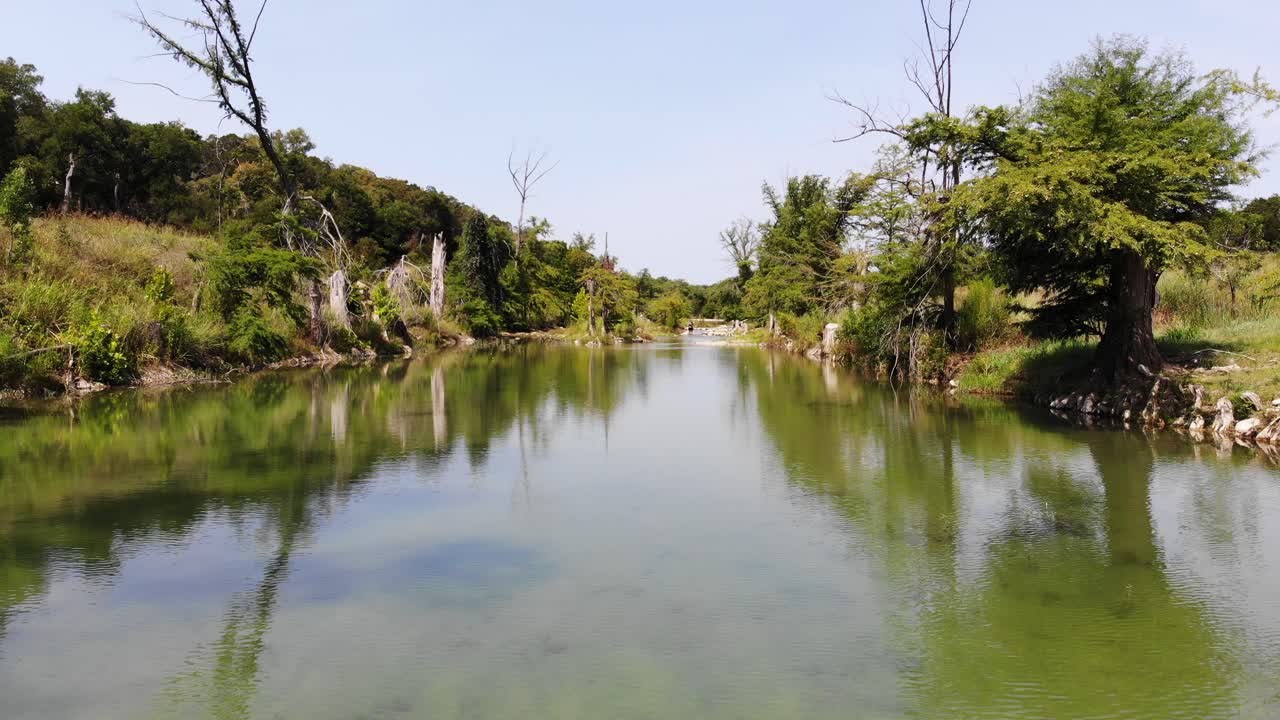 volando rápidamente justo encima del río en una sección abierta hacia una sección boscosa: imágenes aéreas del río blanco en wimberly, tx