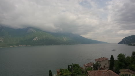 Zeitraffervideo-Mit-Blick-Auf-Den-Gardasee-In-Italien-An-Einem-Bewölkten-Tag-Mit-Sich-Schnell-Bewegenden-Wolken-Und-Vorbeifahrenden-Booten-An-Einem-Bewölkten,-Aber-Sonnigen-Tagesprotokoll