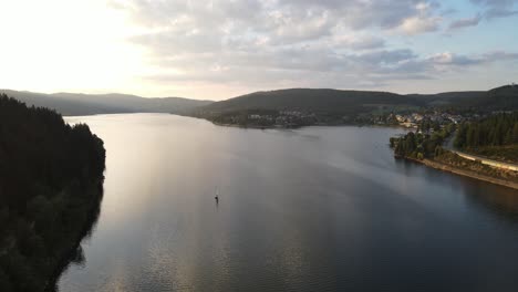 drone filming a small sailing boat at sunset at schluchsee, schwarzwald deutschland