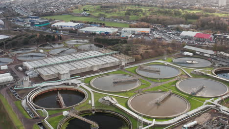 Toma-Aérea-Se-Acerca-A-Una-Gran-Planta-De-Procesamiento-De-Aguas-Residuales-En-Edimburgo-En-Un-Día-Gris