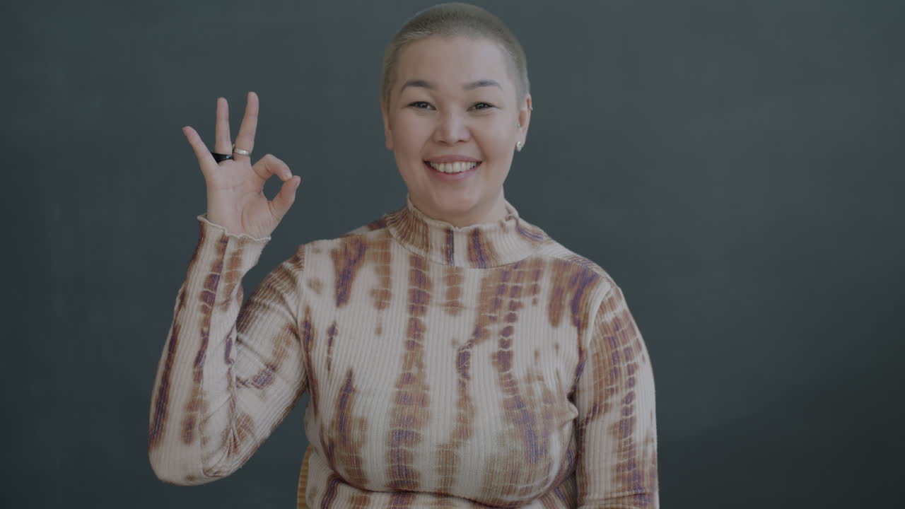 행복한 여성이 ok 신호를 하고 있습니다.