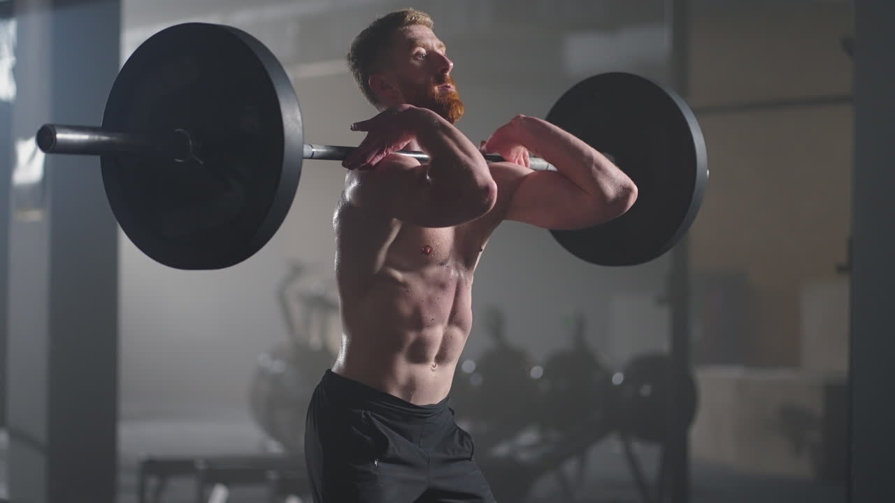 느린 움직임: 피트니스 남자 보디빌더 훈련 바벨을 사용하여 웨이트리프팅 운동 근육 운동 선수 파워 리프팅 무거운 무게 체육관에서 스 ⁇ 을하는 건강한 생활 방식을 즐기는