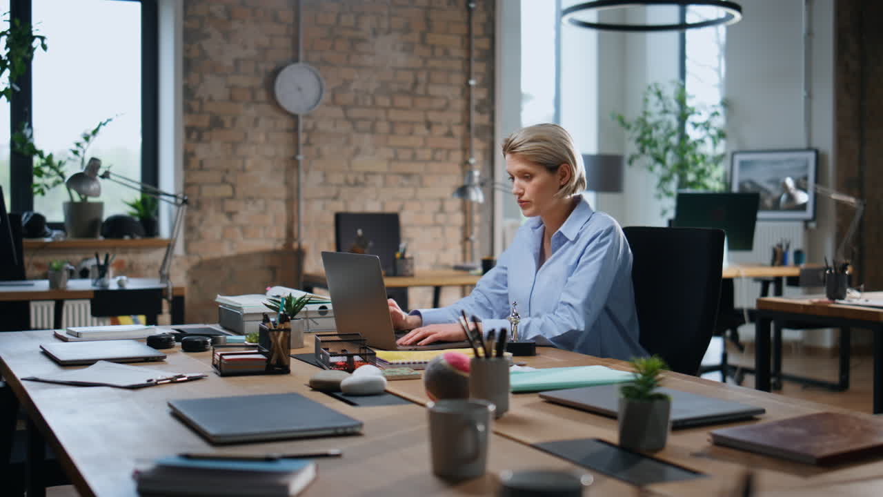 zajęta kobieta biznesowa pisząca laptop siedząca w pustym biurze nadgodziny. zmęczony pracownik