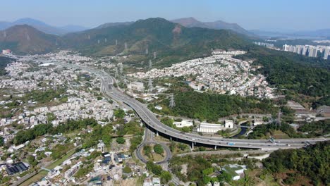 Luftaufnahme-Des-Wohngebiets-Am-Rande-Von-Hongkong-Mit-Verbindungsautobahn-Und-Umliegenden-Berghängen