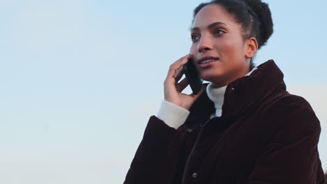 una chica afroamericana hablando por teléfono móvil.