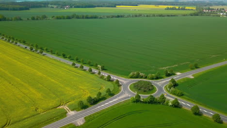 Aerial-view-of-crop-fields-with-road-and-rotary-traffic-winding-through-it