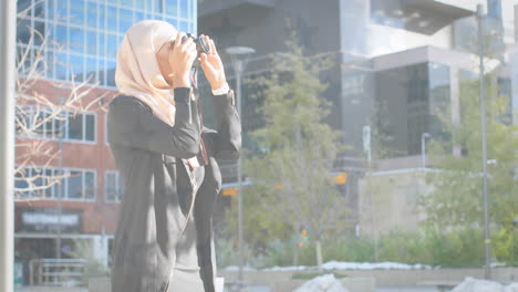 animation of american flag drawn over biracial woman in hijab taking photos with camera