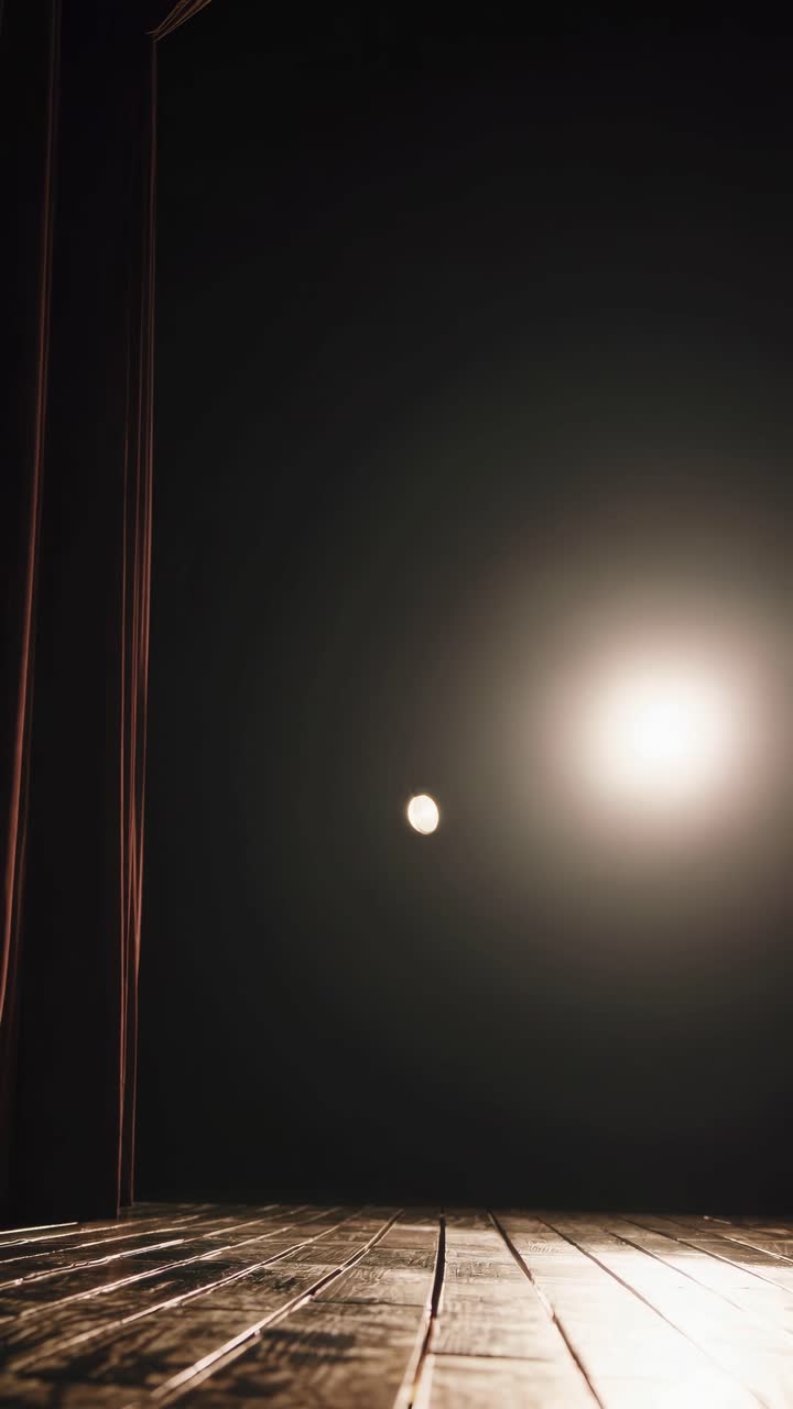 Uma cena de palco dramática com holofote, capturada de um ângulo baixo.
