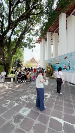 scenes from wat pho temple in bangkok, thailand, with tourists and architectural elements