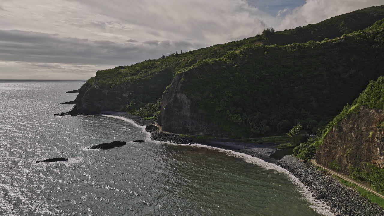 maui hawaii aerial v50 drone cinematográfico vuela a lo largo de la costa rocosa capturando la autopista hana que pasa a través de un terreno montañoso, el puente alelele y kalepa gulch - filmado con mavic 3 cine - diciembre 2022