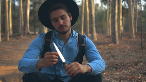 explorador en el bosque jugando con un cuchillo