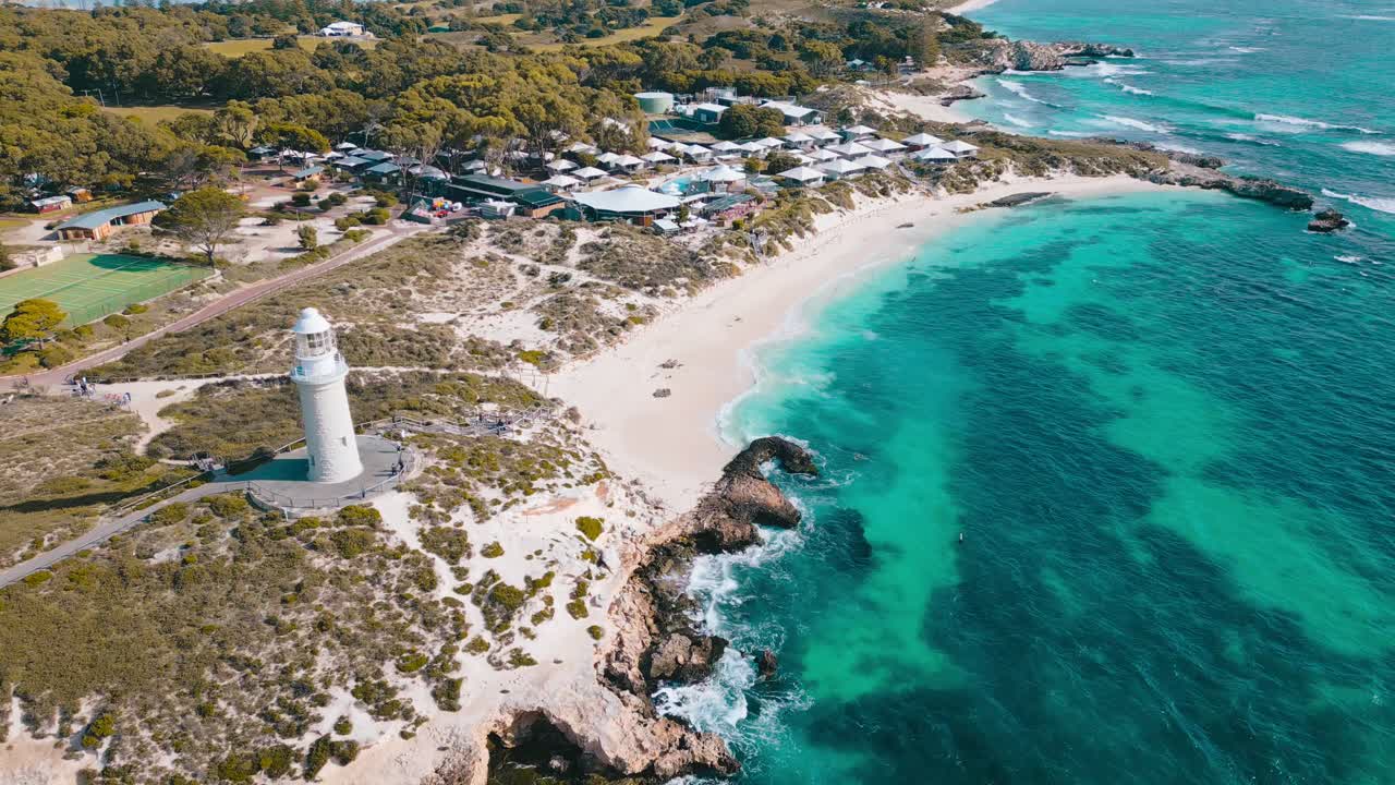 Cinematic aerial footage panning away and upwards from Pinky Beach and Bathurst Lighthouse on Rottnest Island in Perth, Western Australia