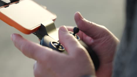 person handling the remote control of an aerial drone