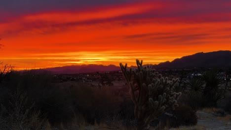 high desert of yucca valley, california during early sunrise with bright orange and red colors beaming in the sky static shot