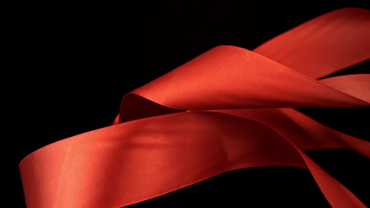 Elegante nastro di raso rosso che si srotola al rallentatore.