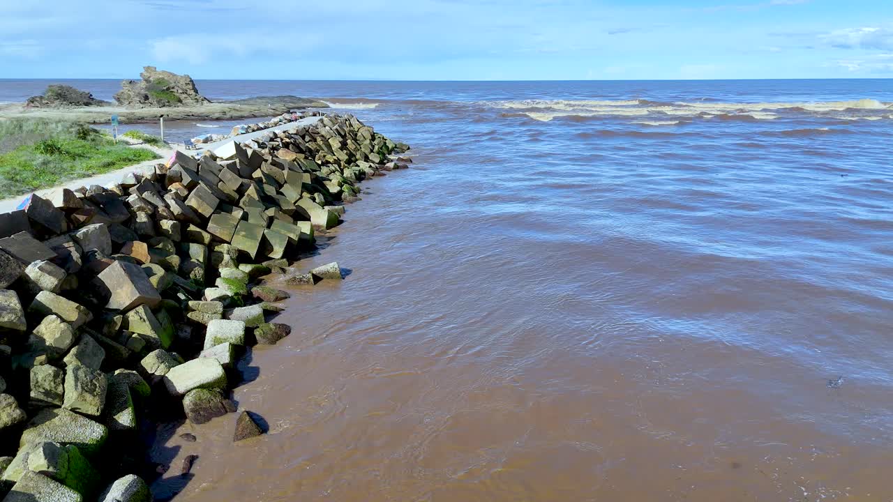 Aerial drone view of stone breakwater where river meets ocean on the Australian coast