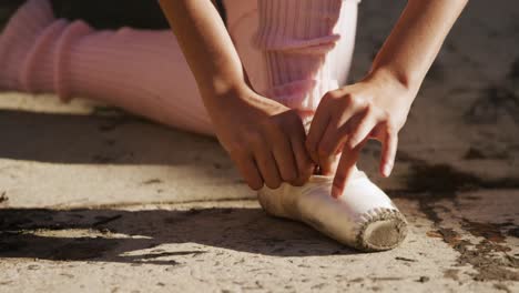 Female-dancer-puts-on-her-ballet-shoes-on-a-rooftop