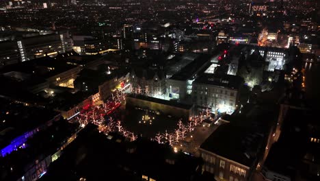 charming atmosphere with decorated lighting christmas trees on market in the hague town at night. aerial top down flyover shot. cold winter day in dutch cityscape. wide shot. het plein square.