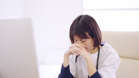 worried female doctor looking at the screen of a computer
