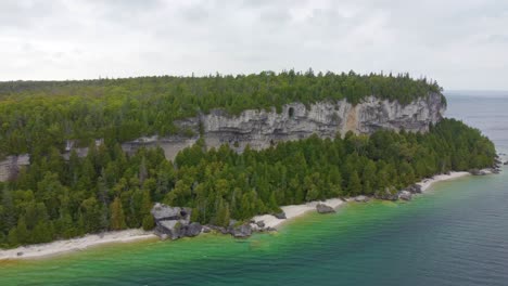 costa rocosa cubierta de bosque cerca del lago, vista aérea