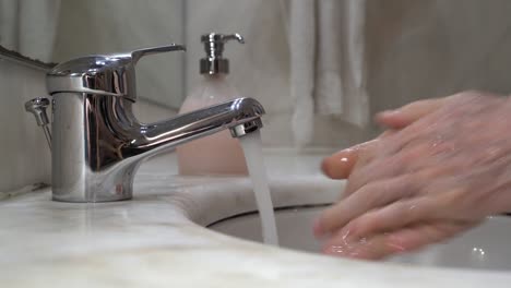 old-man's-hand's-are-washed-on-tap-water-with-liquid-soap,-then-rinsed-and-wiped-on-a-white-cloth-towel---side-view-static-close-up-shot-4k