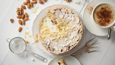 whole delicious apple cake with almonds served on wooden table