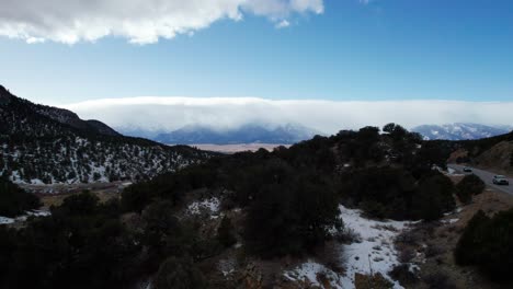 disparo de avión no tripulado que revela hermosas montañas nubladas cubiertas de nieve en colorado