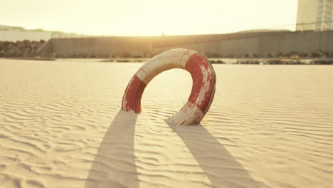 una boya salvavidas solitaria en una playa de arena al atardecer