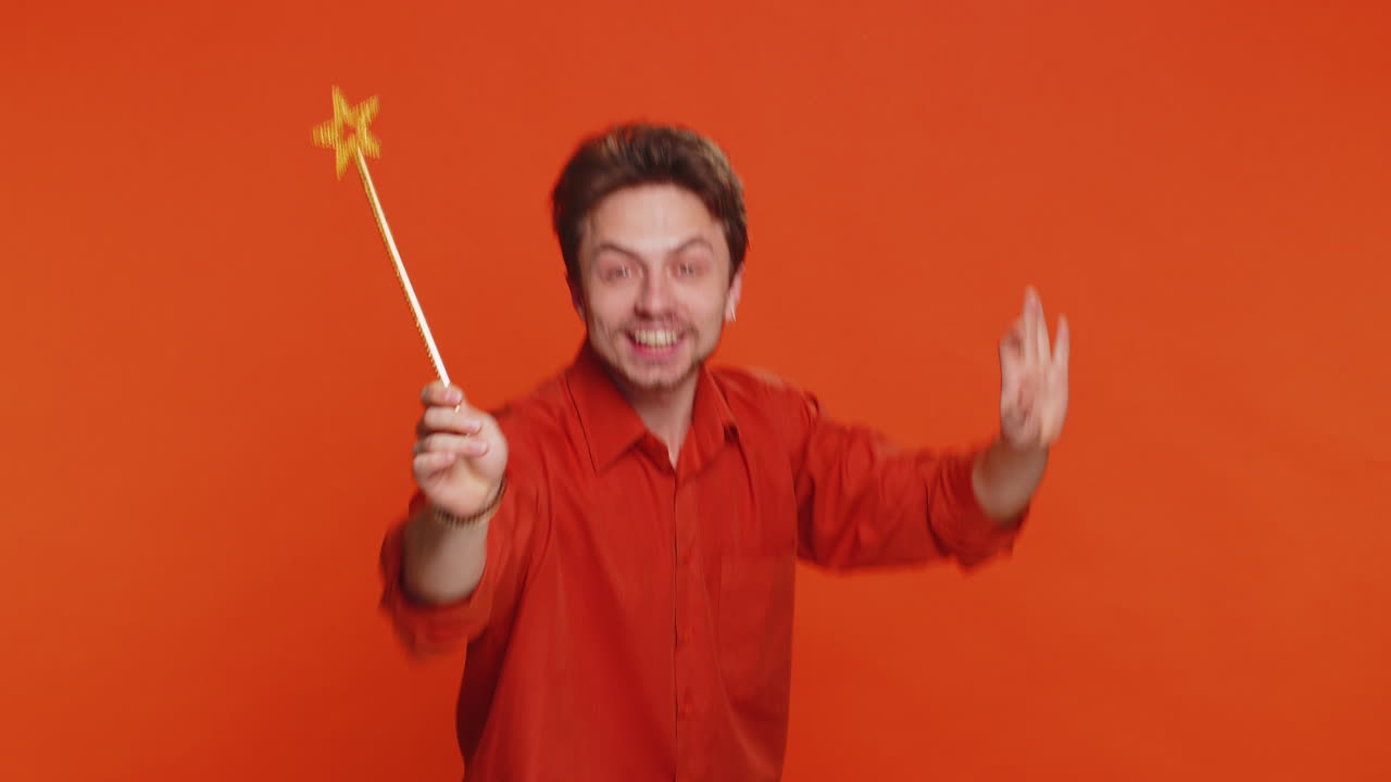 Magician wizard young man gesturing with magic wand making wish come true casting magician spell