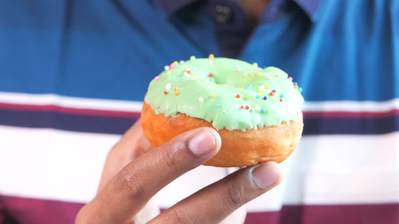persona sosteniendo una rosquilla de vidrio verde