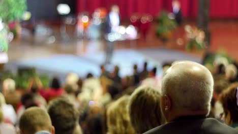 crowd of people to sitting and listening in a large hall