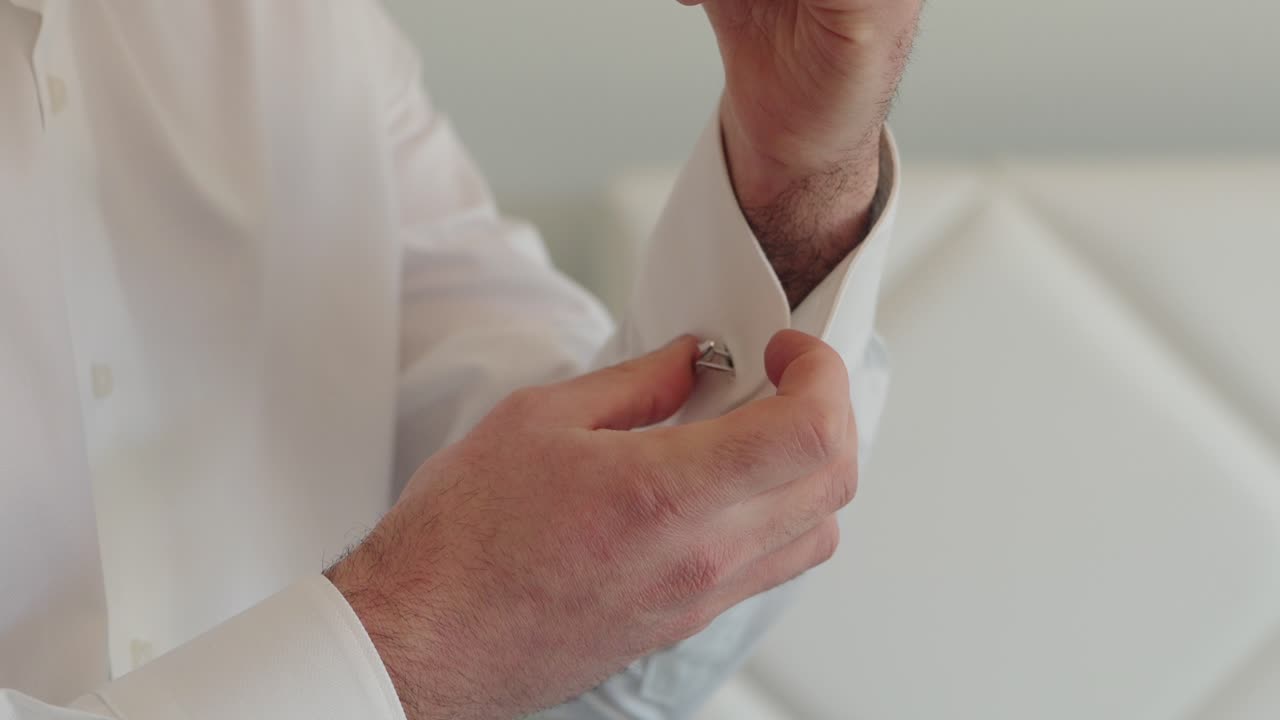 hands adjusting shirt sleeve with care in preparation for special occasion