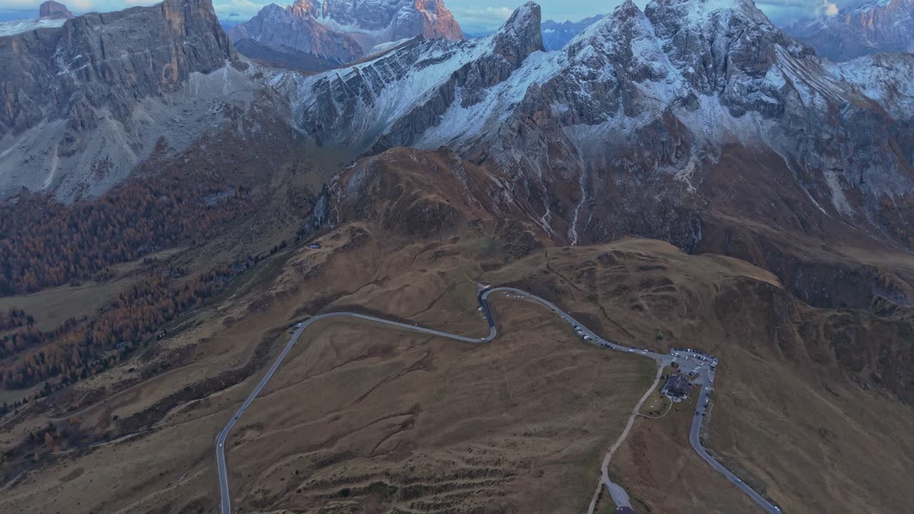 Autumn clouds hug Passo Giau mountain peaks, aerial over Italy