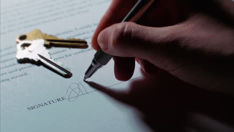 -Close-up-shot-of-a-female-caucasian-hand-signing-a-document,-with-house-or-apartment-keys