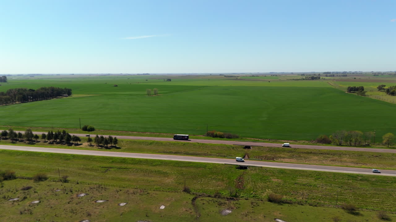 Wide Aerial View of Green Farmland with Busy Highway and Scenic Countryside in Argentina. 4k.