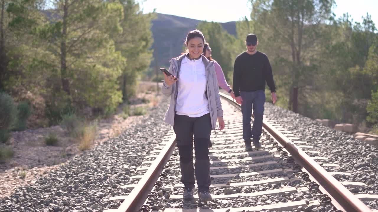 People walking on abandoned railway. Forgotten paths hiker group of backpacker friends. Hiking adventure in nature.