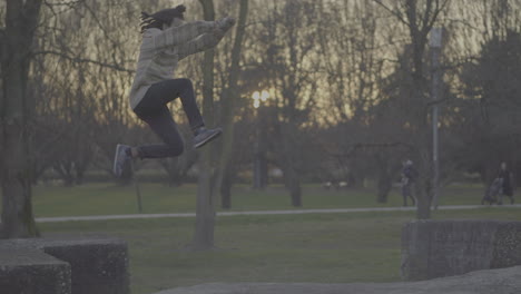 man jumping and sitting in a park at sunset