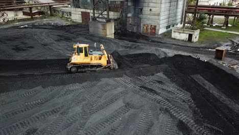 crawler bulldozer sorts coal into a thermal power plant. industry. aerial view.