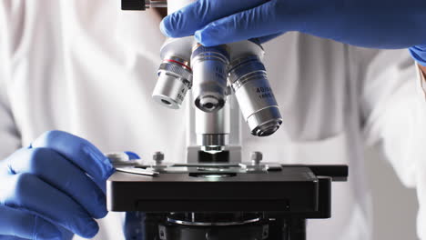 video of close up of scientist using laboratory microscope with copy space on white background