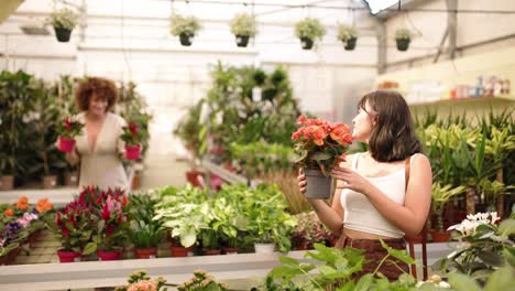 woman smelling flowers in garden center